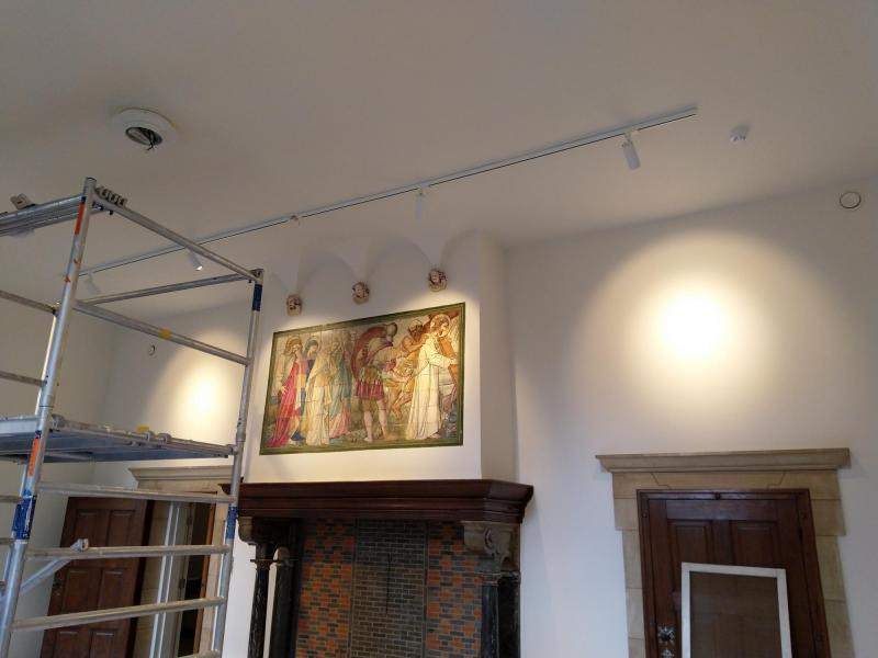 In de grote woonkamer wordt de verlichting opgehangen en uitgetest. 