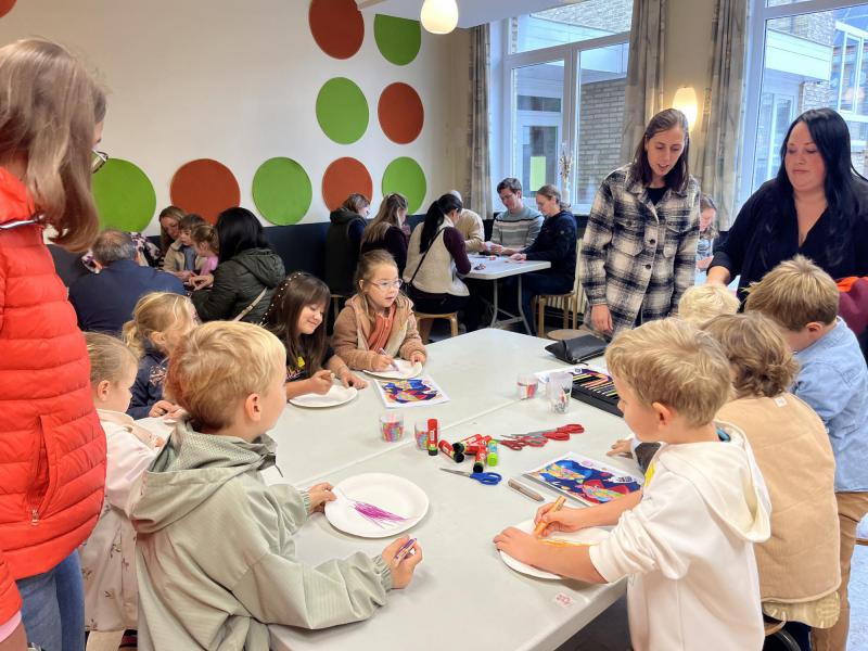 Eerste communicanten knutselen een visje in thema van het evangelie. 