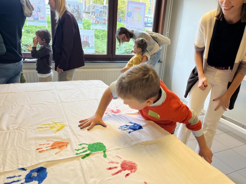 Kinderen zetten hun handdruk op de altaardwaal. 