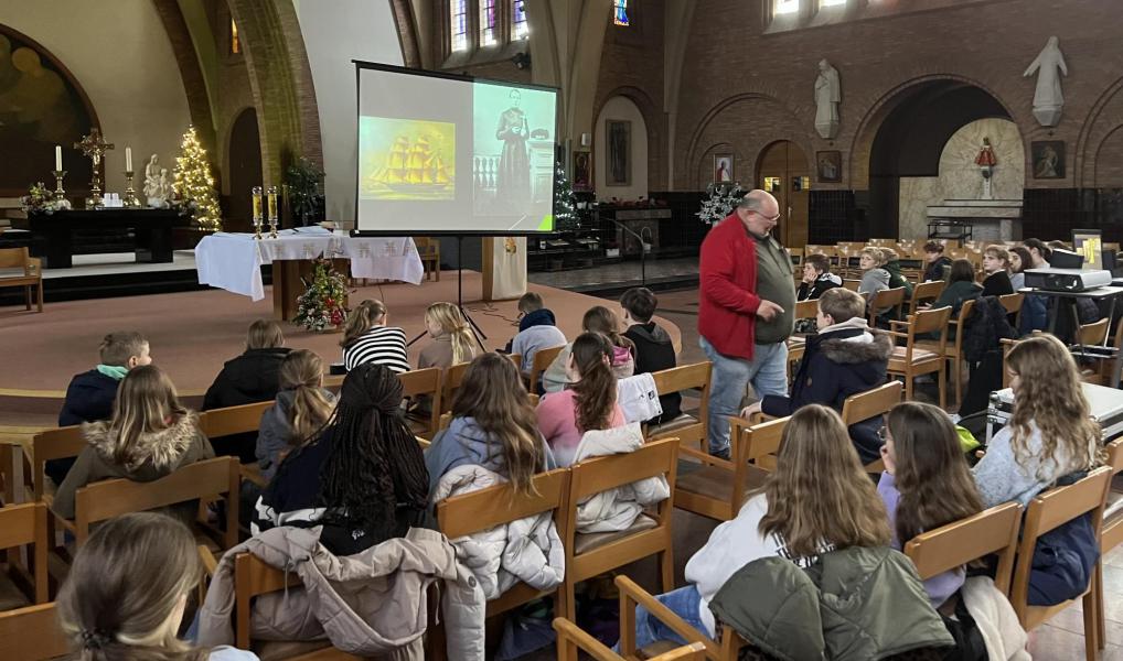 De vormelingen luisteren geboeid naar het verhaal van Pater Damiaan. © Dirk Bellens