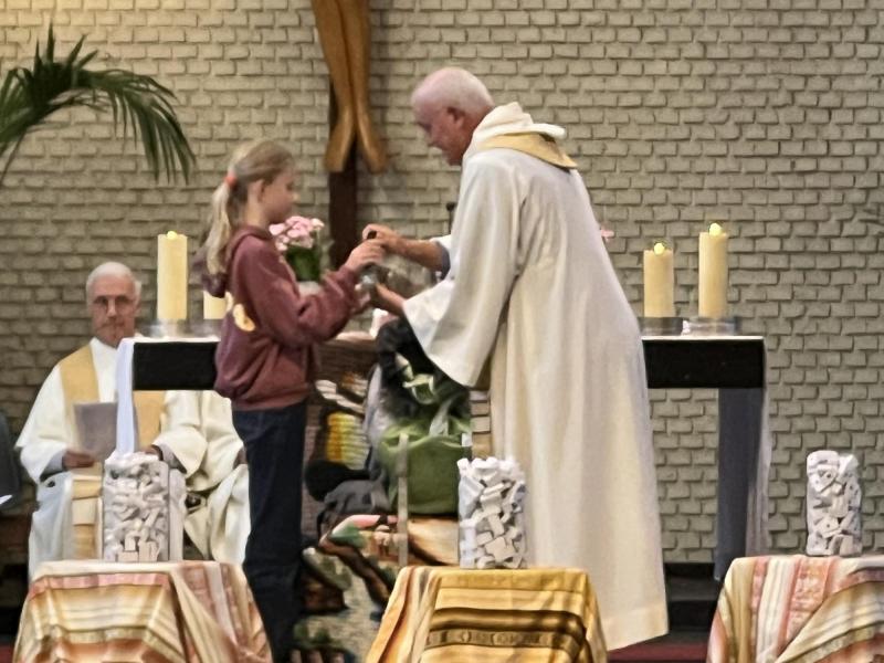 Tijdens de voorbeden wordt de rugzak stap voor stap gevuld met symbolen voor wat de Sint-Michielers dit schooljaar willen meenemen en met elkaar willen delen. © Dirk Bellens
