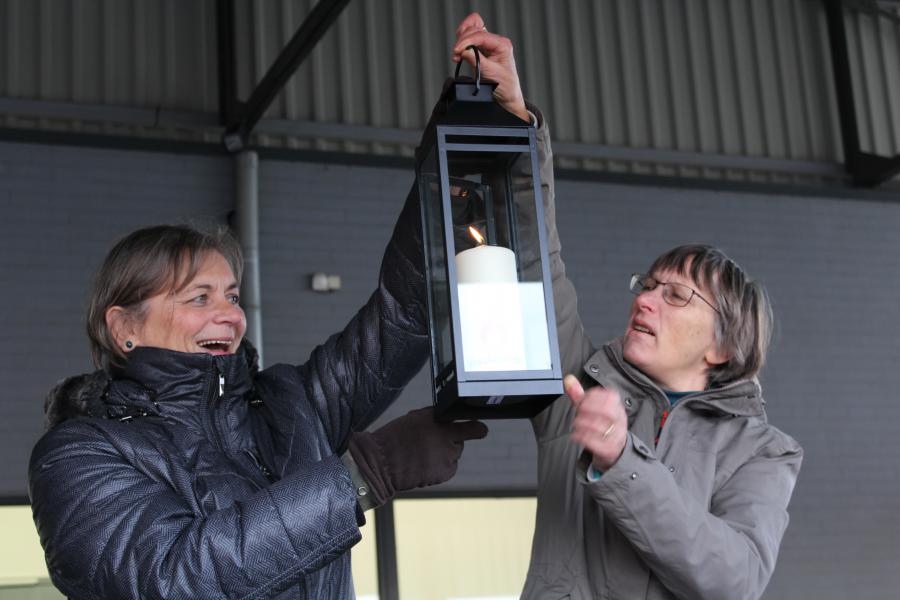 Mia en Sarah tonen de kandelaar met het vredeslicht voor de Gemeentelijke Basisschool © Guido Dumon