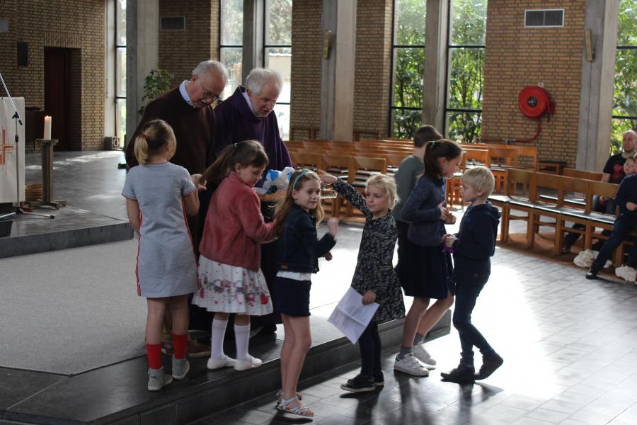 Elke eerste communicant brengt een beetje brood aan om te delen 