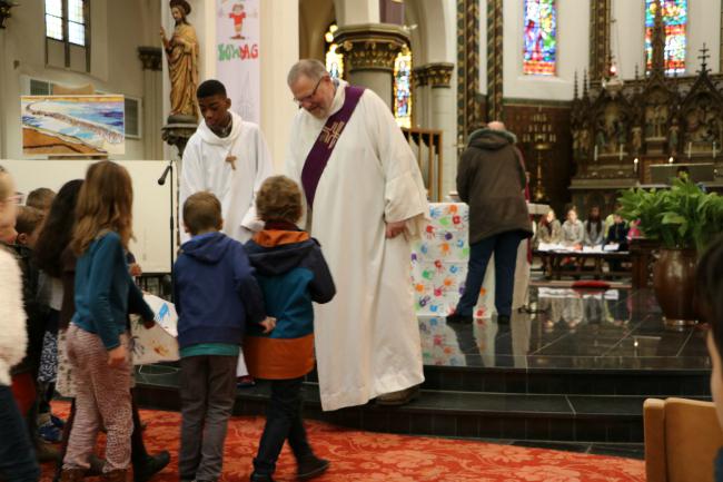 De Diaken Geert Schelfhout en een misdienaar nemen het altaarkleed aan © Kerk Sint-Gillis-Waas