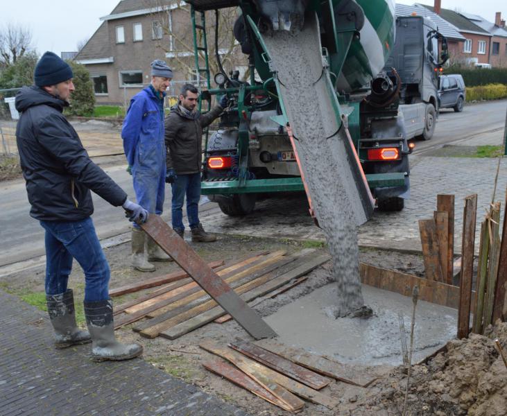 En daar is de betonmolen al. De put wordt netjes gevuld onder zes toeziende ogen.  