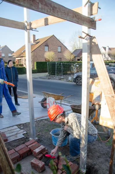 En dan leg Koen Vermeirsch de eerste steen voor de nieuwe kapel. Let op zijn truweel. Voor de gelegenheid is dat versierd met een rode strik. Prachtig, nietwaar! 
