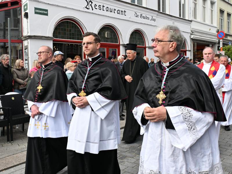 Kanunnik Bart Lagrange tijdens de H. Bloedprocessie in Brugge – Philippe Hallein (links) en Patrick Degrieck (rechts) © -