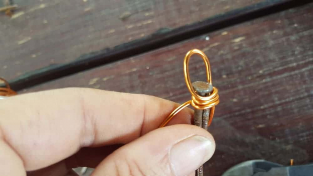 Wikkel de draad voorzichtig om de nagels en het staartstuk van de lus. 