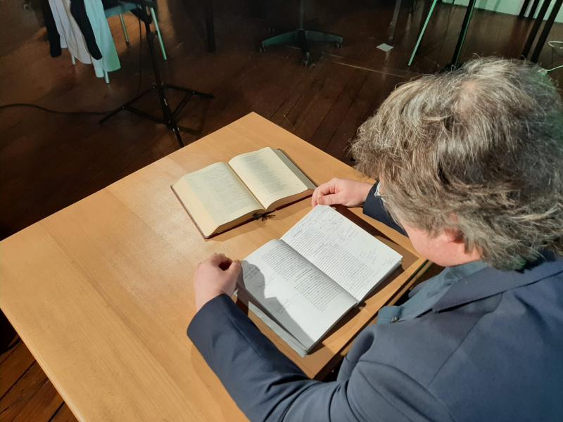 Vicaris Bart Paepen aan tafel met werkboek en Grieks Nieuw Testament © Chris van Vliet