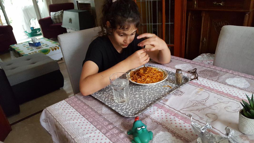 Na een hele dag op het speelplein geniet Morya van een lekker bord spaghetti. © Dirk Adams