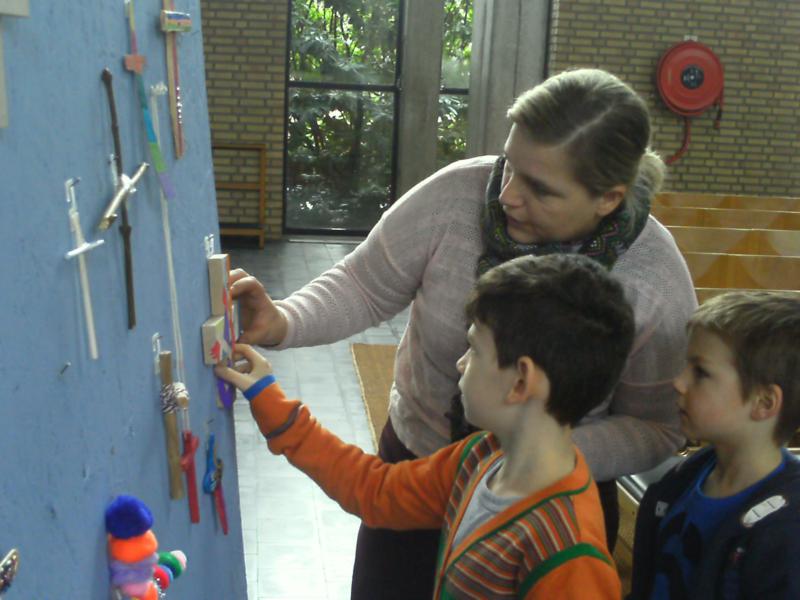 De kruisjes die de kinderen thuis geknutseld hebben worden op het grote bord gehangen 