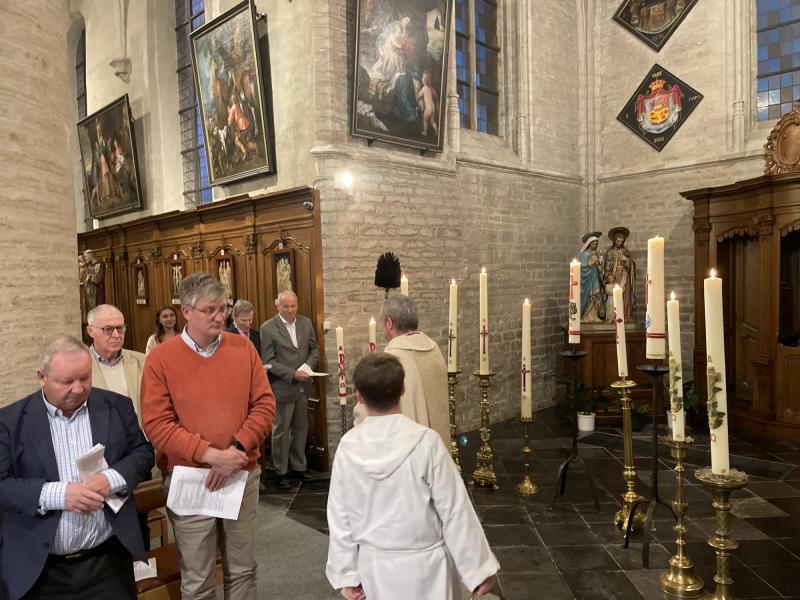 Pater Patrick besprenkelt de mensen in de kerk met pas gewijde water 