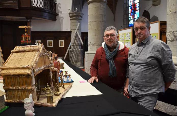 Johan Soetaert, voorzitter van de kerkfabriek Sint-Christoffel in Pollare (rechts op de foto), en William Minnaert van VVV-Ninove die de rondleidingen geeft, tijdens de opbouw van de kerststallententoonsteling bij een kerststal uit het Afrikaanse Burkina  © Claudia Van den Houte