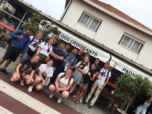 WJD 2023 - groepsfoto aan de bakkerij die verse Portugese croissants verkoopt © Servaes Seifi