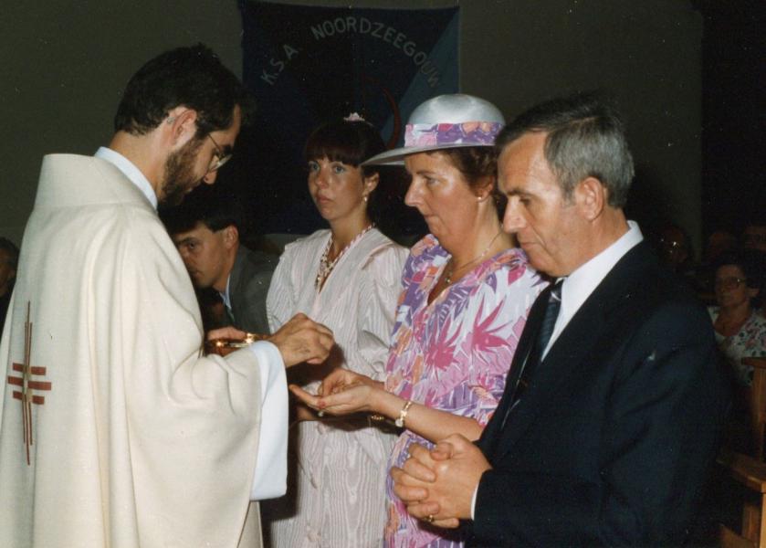 De ouders en zus van de pas gewijde priester gaan bij hun zoon ter communie. © Christ Demeester