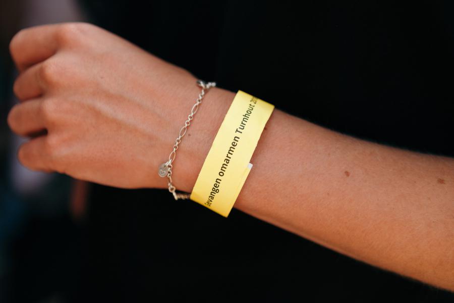 Het gele armbandje verwijst naar het themalied, over een geliefde die een geel draadje aan een oude eik hangt als teken van verbondenheid. © Mathias Hannes