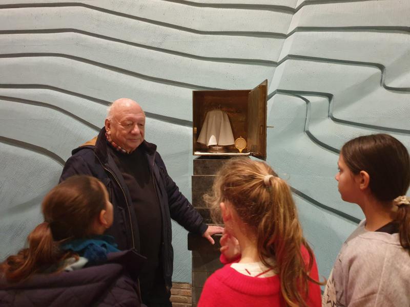 Pastoor Johan ontvangt ons in het koor van de kerk bij het altaar, het tabernakel waarin de heilig hosties worden bewaard, de godslamp, de paaskaars, de lezenaar... © Kleopas