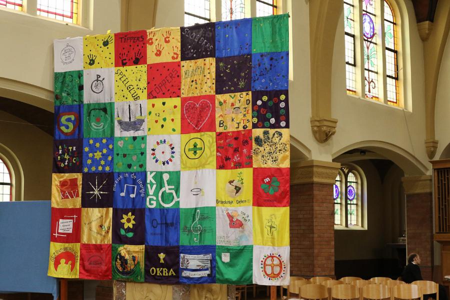 Onze mooie vlag waaraan iedereen meewerkte hing vooraan in de kerk.