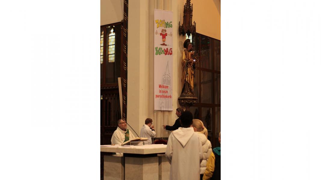 De banner nog even recht hangen. © Kerk Stekene en Sint-Gillis-Waas