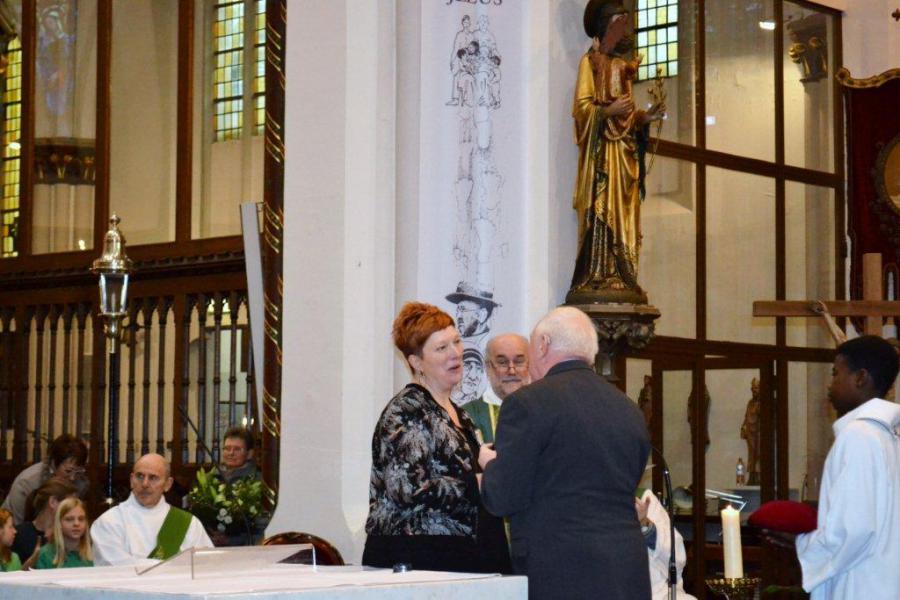 Bloemenhulde aan organiste Christina door een vertegenwoordiger van het Andanté koor 