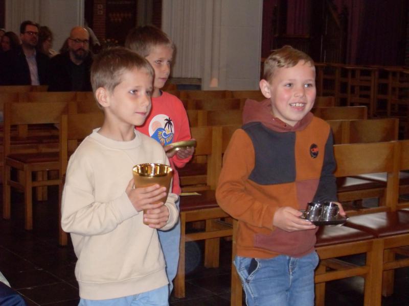 De eerste communicanten brengen de gaven aan © RvH