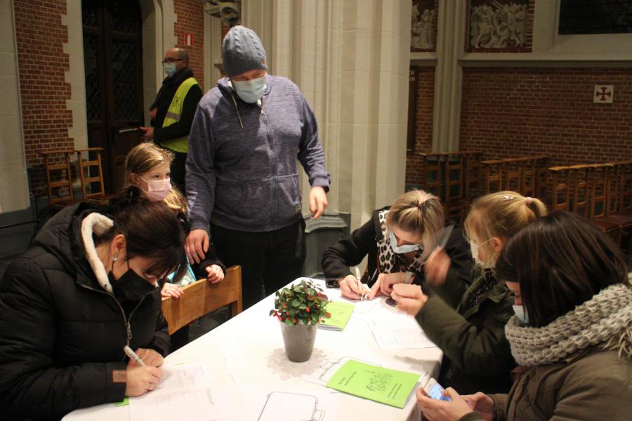 Kinderen kijken blij toe als mama/papa hen inschrijven voor hun eerste communie © RvH