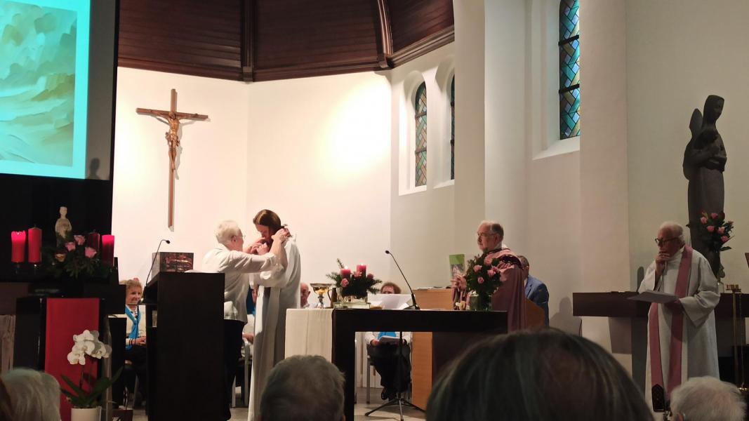 Zuster Arlette overhandigt een kruisje dat voor haar heel dierbaar is aan Evelyne 