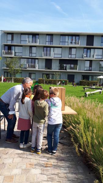 Leerlingen plaatsen een bloem in de kistjes ter herdenking 