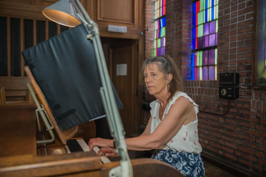pianiste-componiste-orgeliste Nicole De Paepe begeleidde de kinderen op de piano en speelde de sortie boven op het grote orgel © Sandra Janssen en Wim Duysburgh