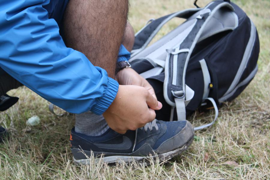 Yassine van ons Dapperevoetjesteam bindt zijn schoenen vast.