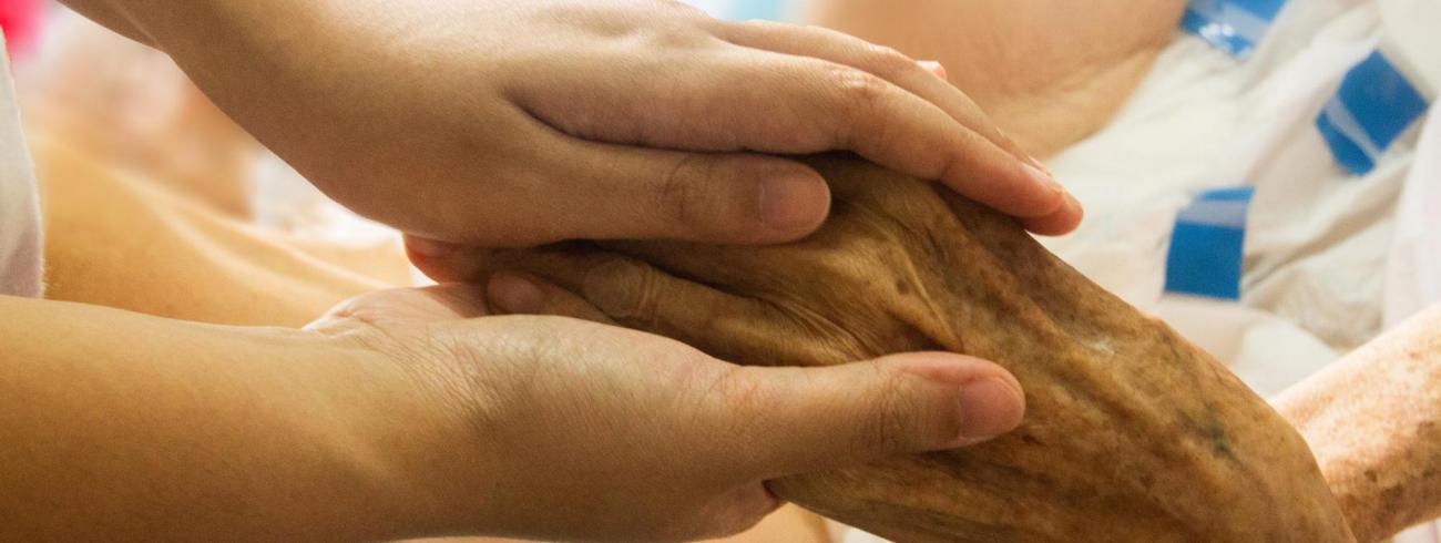 een hand geeft een hand aan een patiënt in een ziekbed © pixabay