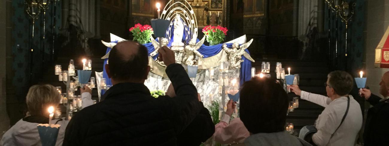 Kaarsenprocessie binnen door regenweer. © bedevaartsoord
