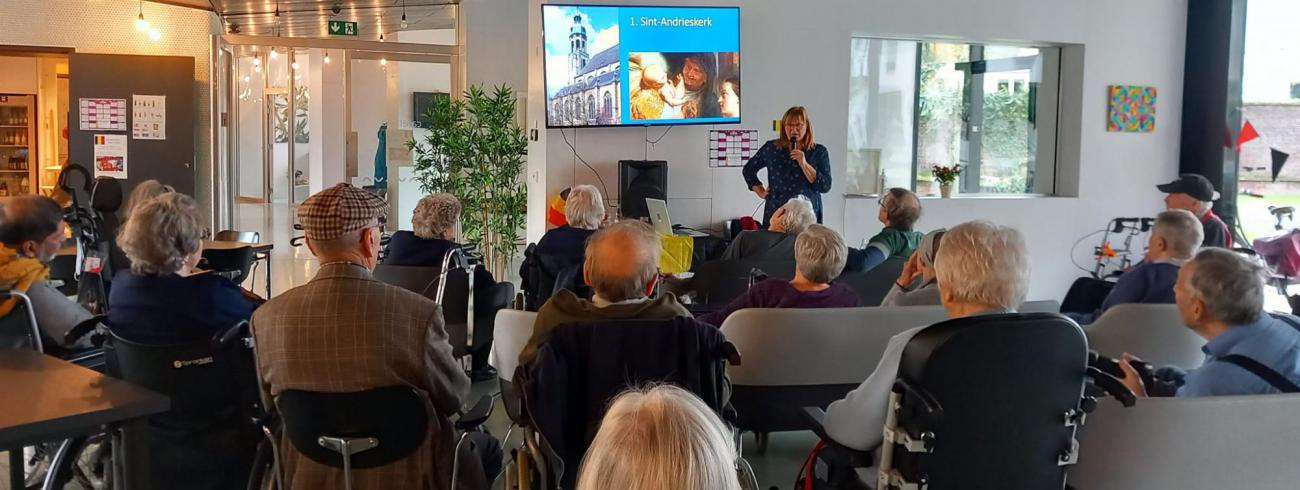 Gids Marianne neemt de bewoners van wzc Hollebeek mee op wandel door schilderijen van Rubens uit Antwerpse monumentale kerken. © wzc Hollebeek