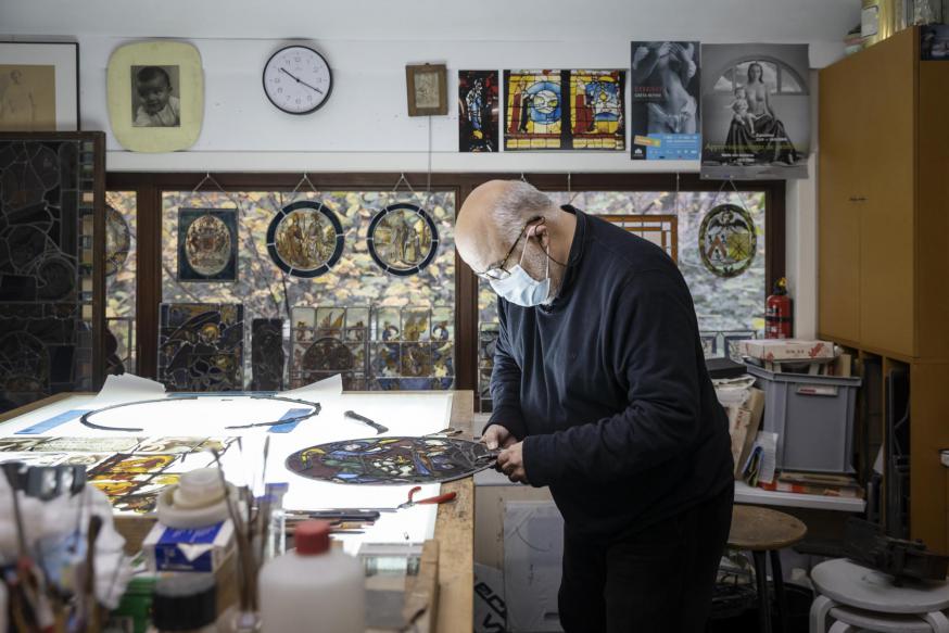 Joost Caen aan het werk in zijn atelier, een schatkamer die heel wat waardevolle  glasramen onderdak biedt.  © Ans Brys
