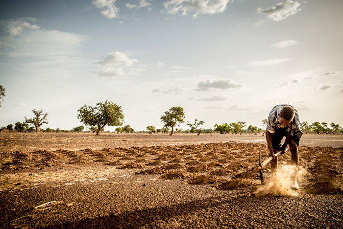 Een boer bewerkt zijn grond in Burkina Faso © Thomas De Boever/Broederlijk Delen