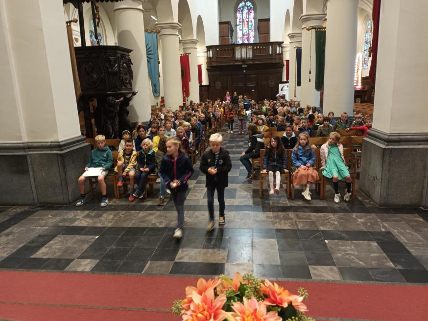 De leerlingen van het 1ste,2de en 5de leerjaar brengen tijdens de offerande kaarsen, bloemen, brood en smilies tot bij het altaar. © parochie onze lieve Vrouw Lichtaart