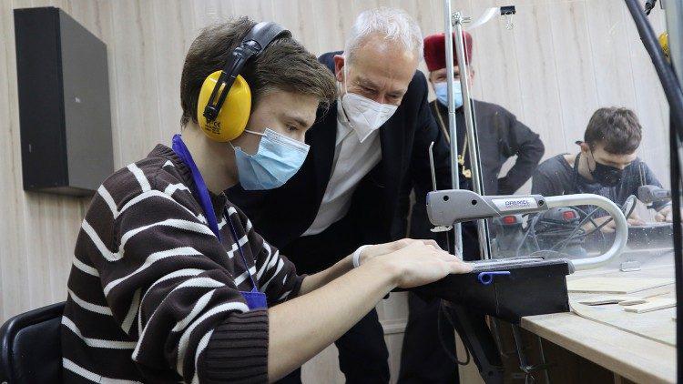 Een jongen krijgt les houtbewerking in een sociaal centrum van Caritas in Kramatorsk in Oekraïne © VaticanMedia