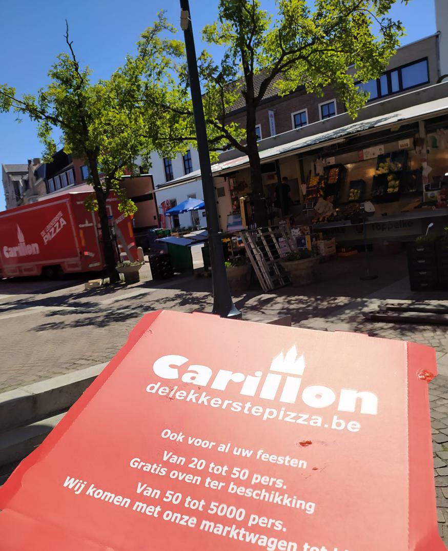 Tussen twaalf en één eet iedereen, ook de studenten. Even een lekkere pizza halen op de wekelijkse markt rond de kerk. Werd de pizza gesponsord voor deze reportage? Wie zal het zeggen?  © D.D.