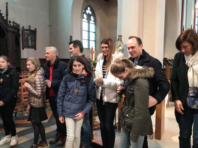 De kandidaat-vormelingen ontvangen het vormselkruisje van hun ouders. 