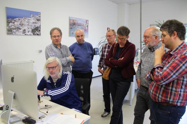 Fons legt uit hoe hij de tekst en foto’s op een pagina schikt. Achter hem luisteren geboeid (v.l.n.r.): Tom Heylen, Geert, Bob, Martine, Daniël en Tim. © HVDS