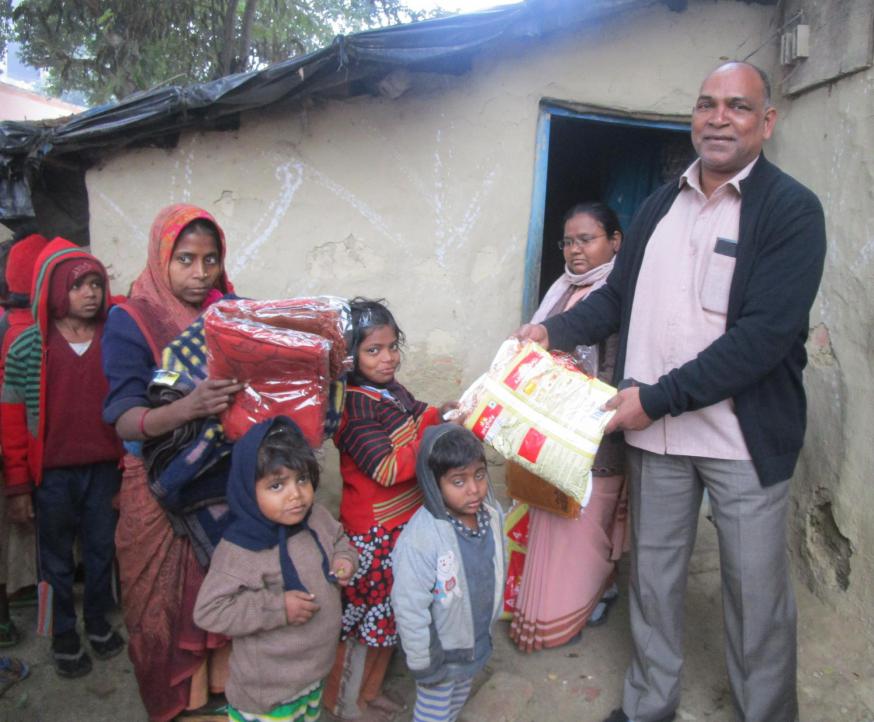 Amal deelt kleding uit in slum 