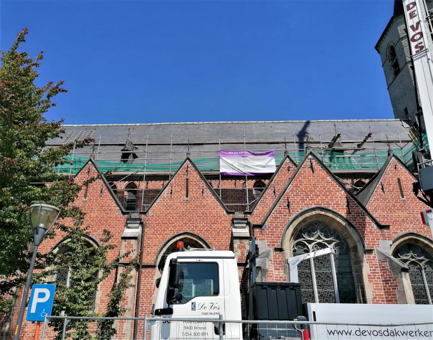 De nokpannen worden opnieuw geplaatst als kroon op het werk 