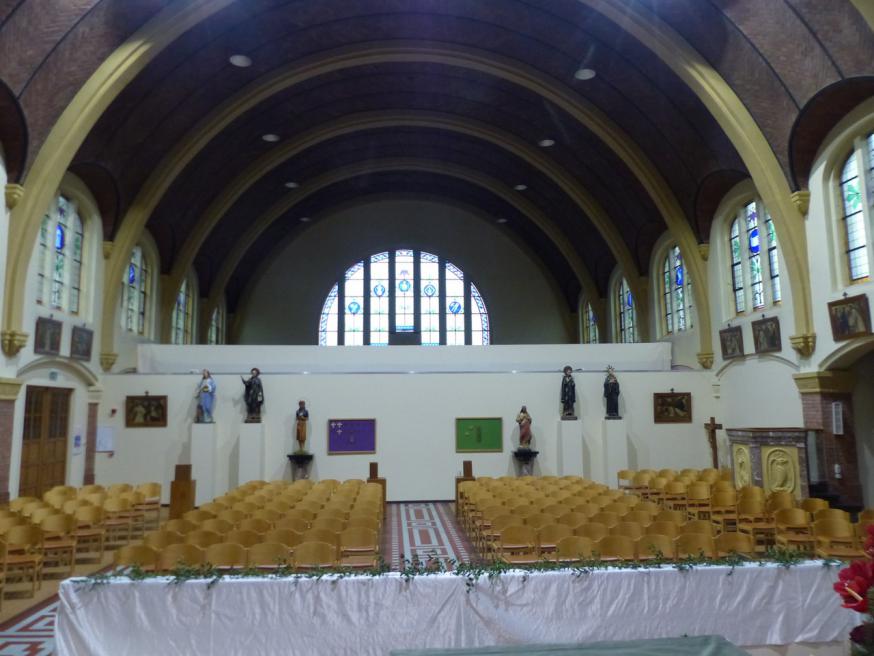 De nieuwe achterwand van de kerk. Op de open ruimte komt de Passionistenvlag uit 1933 als verwijzing naar de pioniers van onze parochie. 