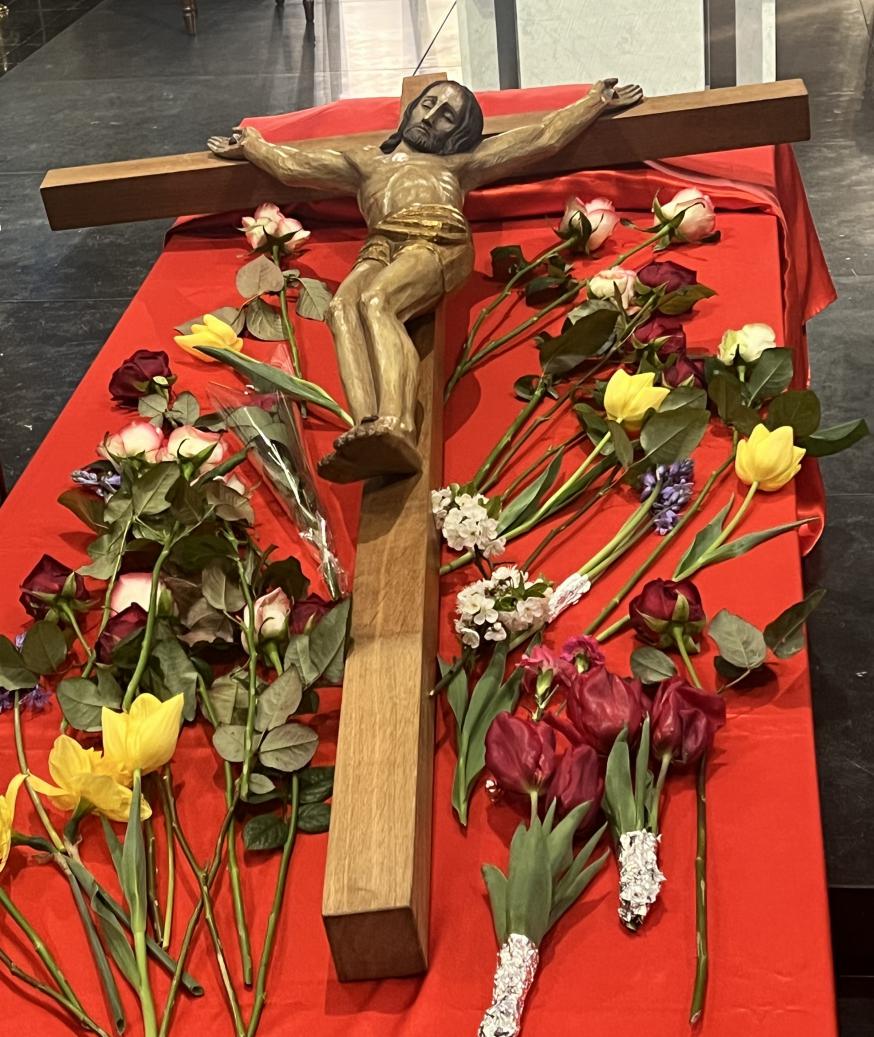 Mensen eren het kruis met een bloem 