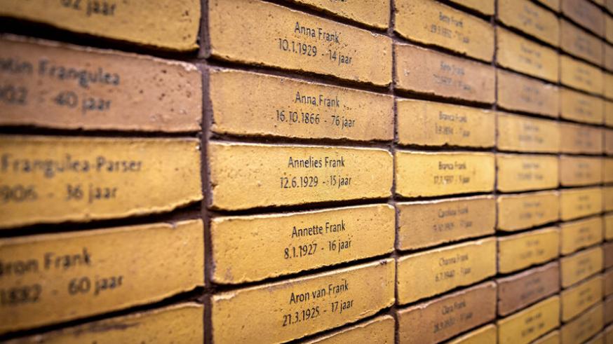 Het Holocaust Namenmonument in Amsterdam. Je herkent de naam van Anne Frank. Boven de installatie zweven de letters van het Hebreeuwse woord voor 'gedenk'. © RR Het Holocaust Namenmonument in Amsterdam. Je herkent de naam van Anne Frank. Boven de installatie zweven de letters van het Hebreeuwse woord voor 'gedenk'. © RR