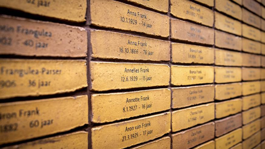 Het Holocaust Namenmonument in Amsterdam. Je herkent de naam van Anne Frank. Boven de installatie zweven de letters van het Hebreeuwse woord voor 'gedenk'. © RR