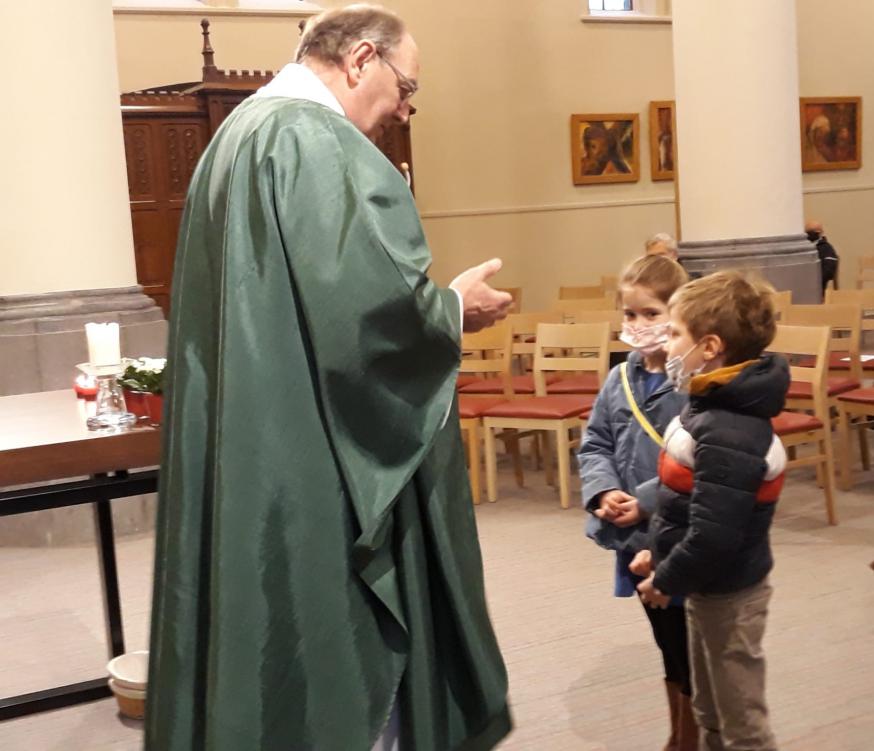 Priester Filip in gesprek met enkele eerstecommunicanten in de weekendviering in Sente © Lieve Vancraeynest