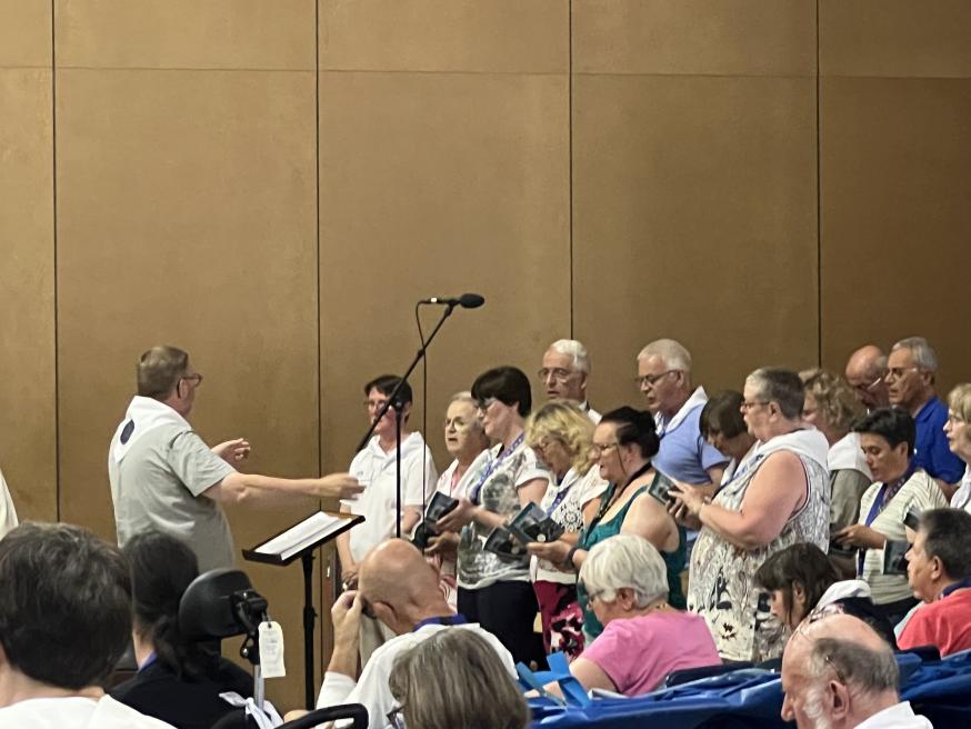 Het koor zingt onder leiding van Chrétien 
