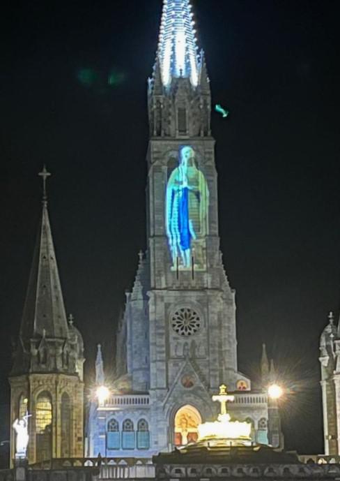Boven op de toren van de Rozenkransbasiliek wordt de beeltenis van Maria in de grot geprojecteerd © Pastorale zone Leuven aan de Dijle