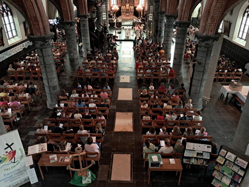 Kinderen brengen bezinnende teksten voor kinderen in een volle Heilig Kruiskerk. 